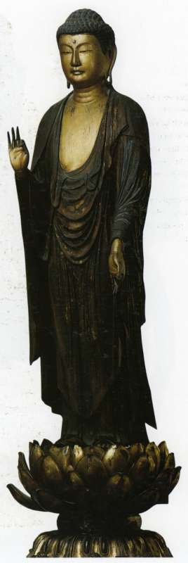 Amida Buddha standing on a lotus base, backed by a flaming halo